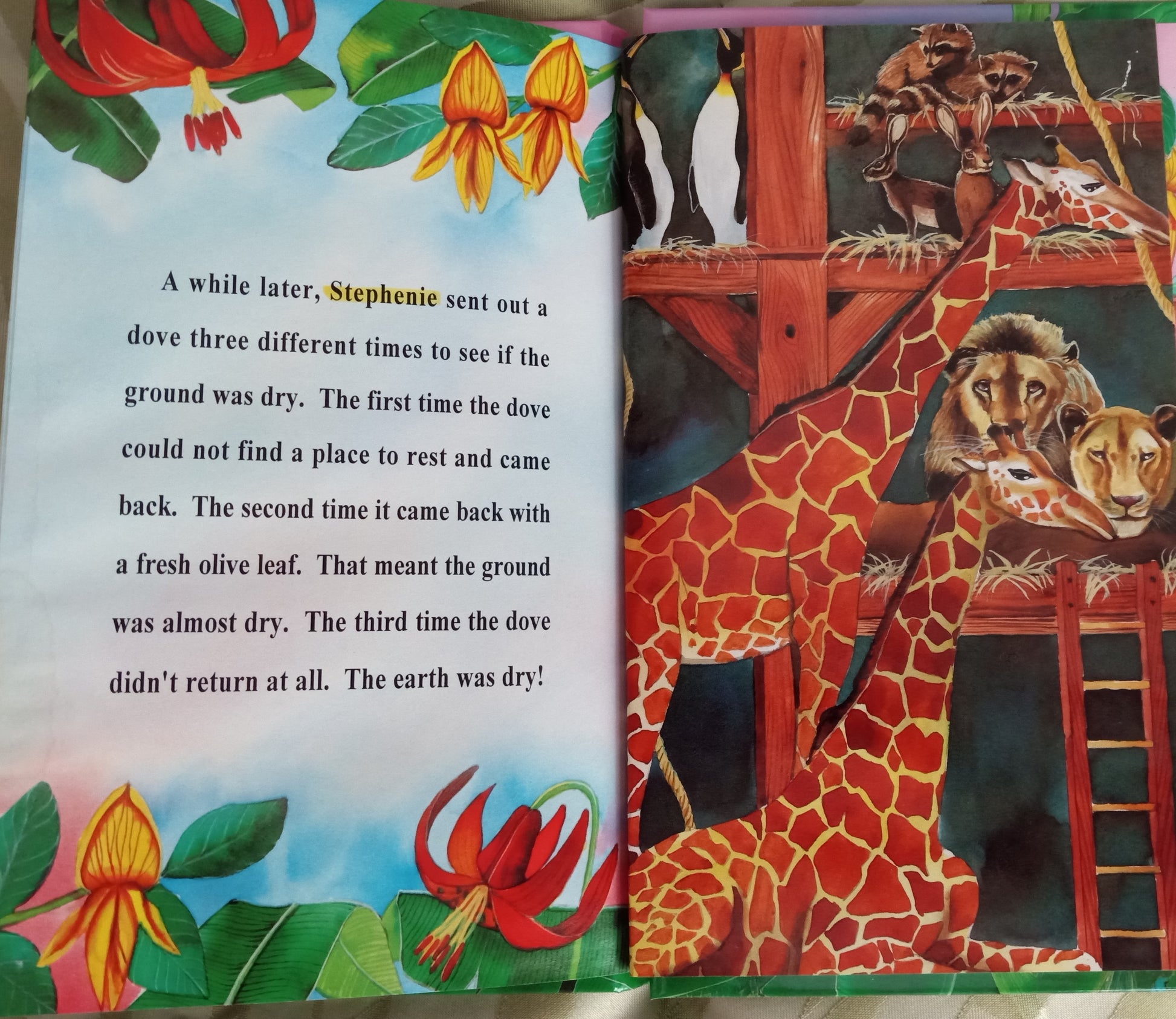 Open personalized book with a colorful illustration of a giraffe and lions, and personalized text Noah's Ark